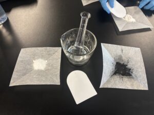 Baking soda, mortar and pestle, spatula, and activated charcoal
